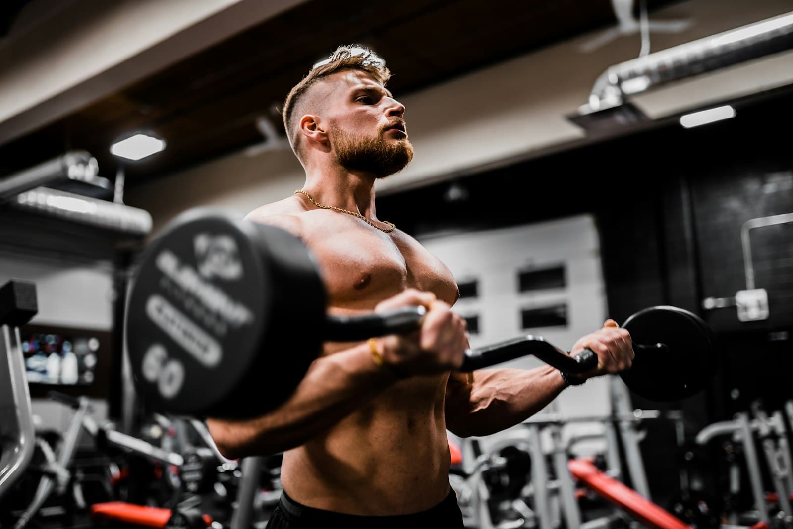 A member mid-set under focused gym lighting at Optimum